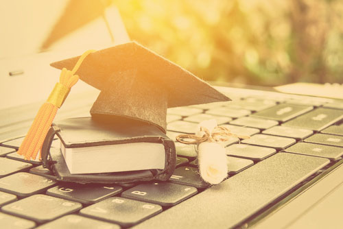 graduation hut und Planner auf einem Laptop